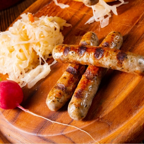 Bratwurst mit Sauerkraut auf einem Brett