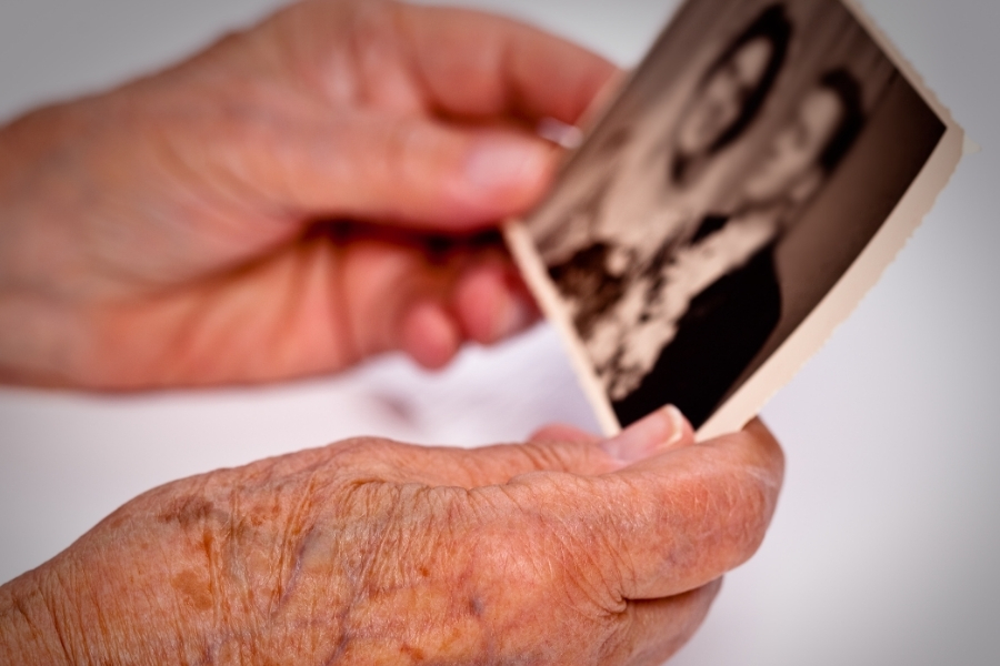 Hände einer Seniorin mit altem Hochzeitsfoto