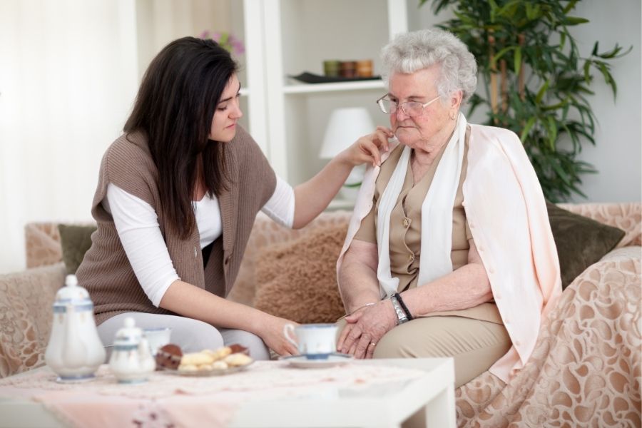 Pflegekraft kümmert sich um kranke Seniorin