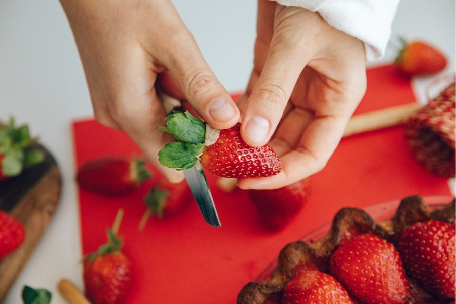 Pflegekraft schneidet Erdbeeren