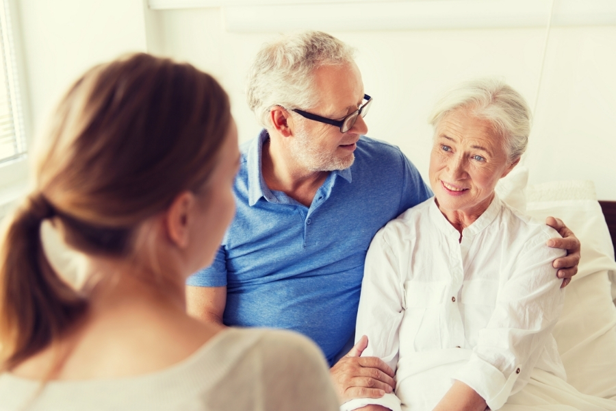 Angehöriger zu Besuch bei pflegebedürftiger Seniorin