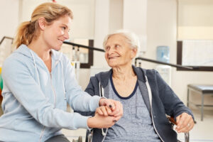 Pflegekraft mit glücklicher Seniorin