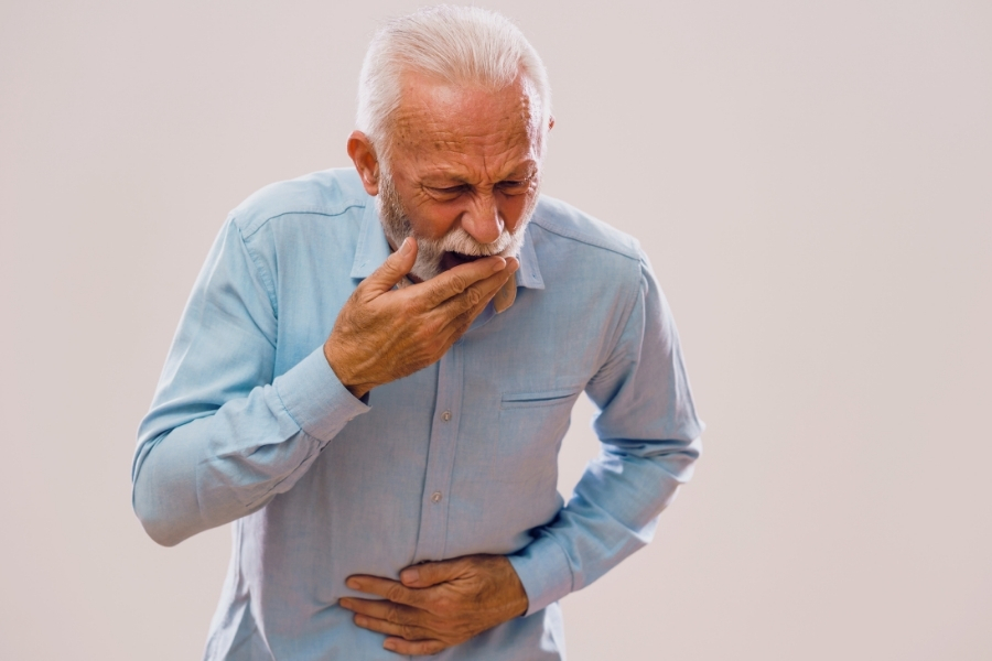 Senior hält sich den Bauch