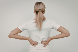 Frau hält sich den Rücken