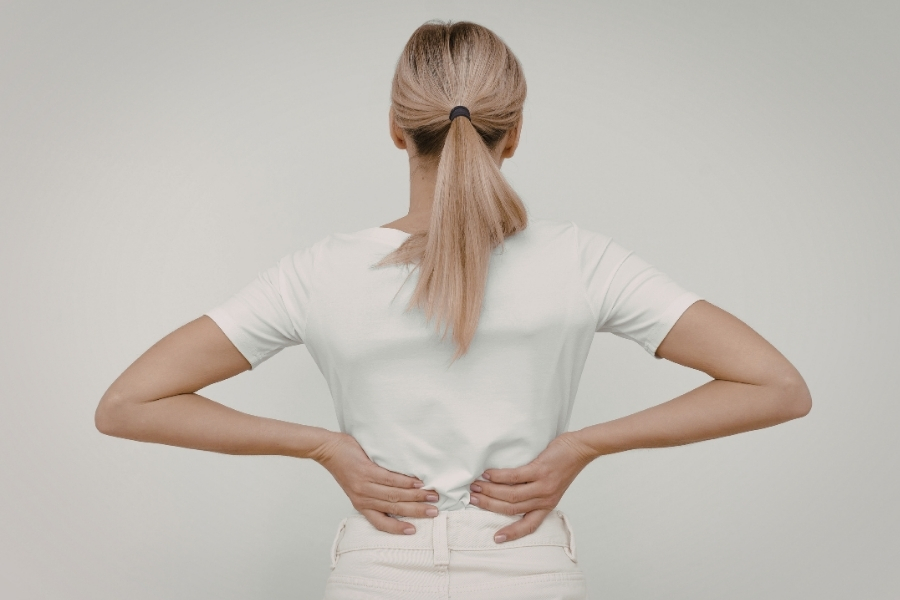 Frau hält sich den Rücken